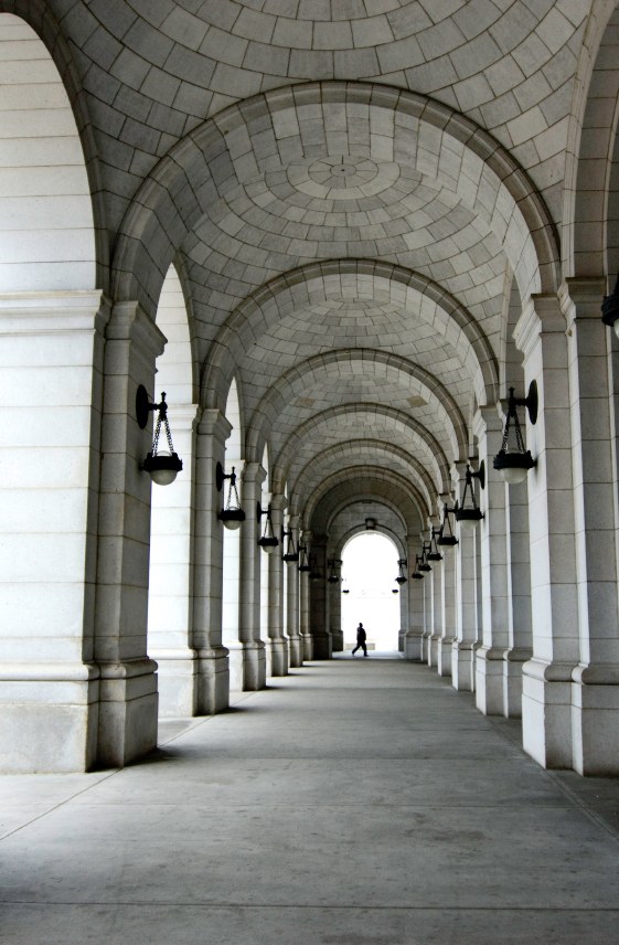 A stone arcade receding toward a lit doorway